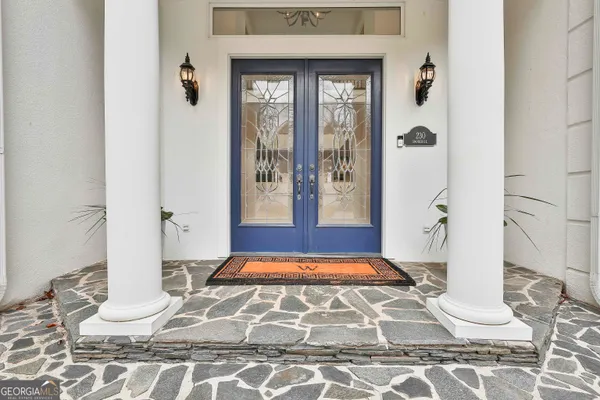 a view of entryway and hall with dining room and wooden floor