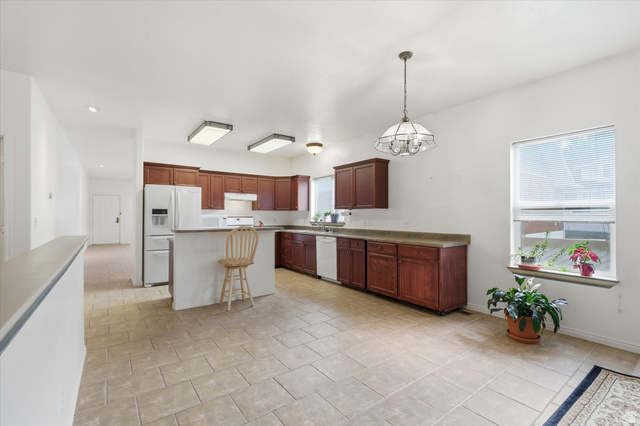 560 East 700 North Logan, UT 84321 - Photo 5 of 32 Spacious kitchen featuring warm wood cabinetry, light-toned countertops, and tile flooring