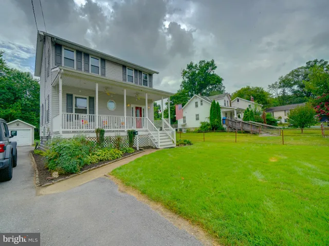 a front view of a house with yard and green space