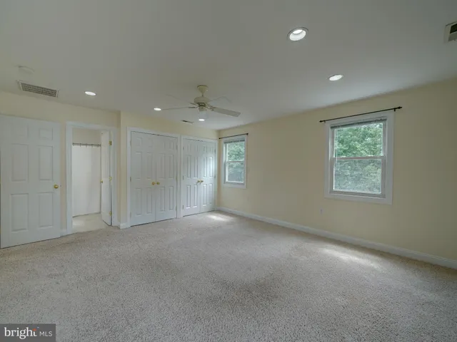 a view of an empty room with window and closet area