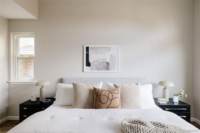 a bedroom with a bed and a painting on the wall