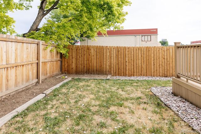 a view of a backyard with a fence and plants