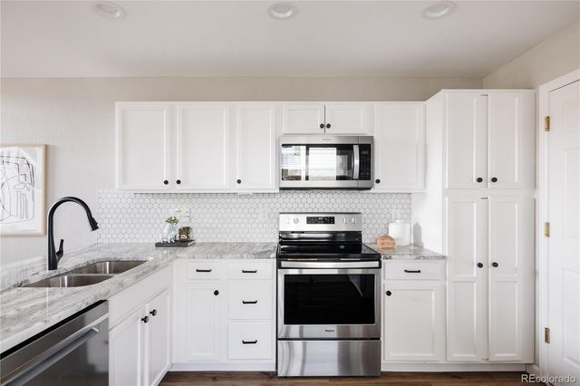 a kitchen with stainless steel appliances granite countertop a stove a sink and a refrigerator