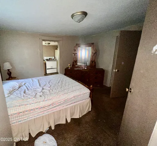 a bedroom with a bed and dresser with mirror