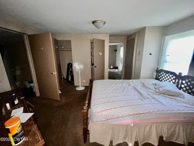 a bedroom with a bed and a flat tv screen on dresser