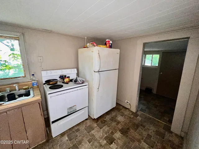 a kitchen with sink refrigerator and stove