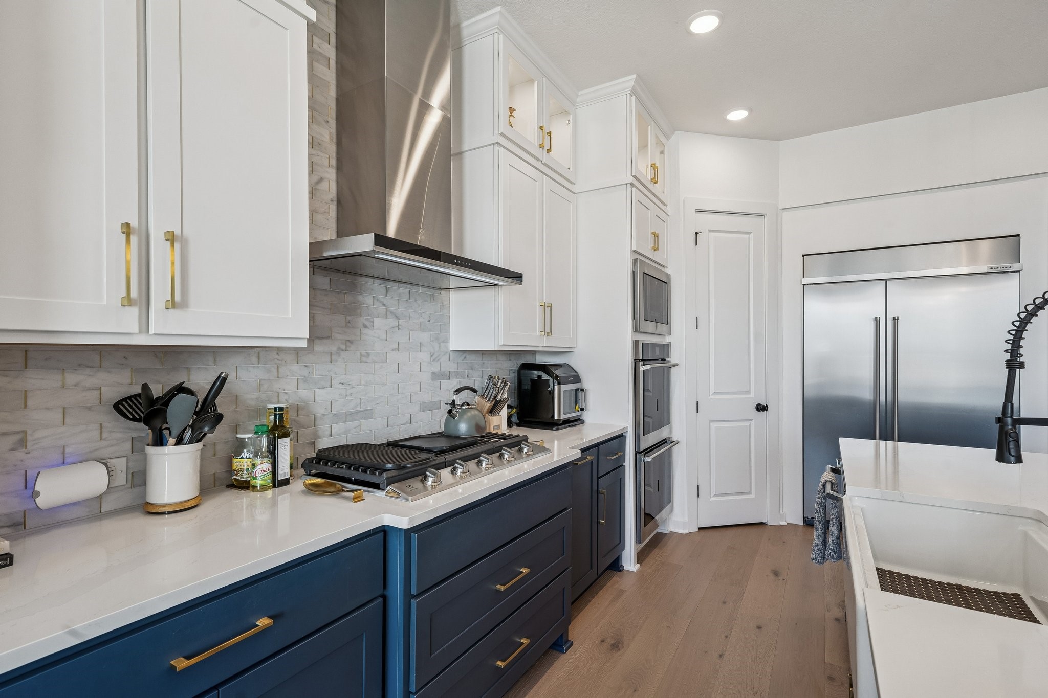 8703 Blue Grotto Lane Manvel, TX 77578 - Photo 11 of 43 High-end appliances including heavy duty gas cooktop and high capacity hood framed by the marble backsplash all the way to the ceiling.