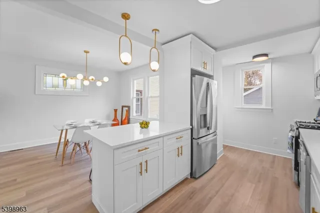 a kitchen that has a lot of cabinets and wooden floor