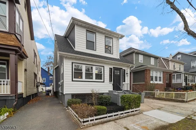 a view of a white house with a large windows and a tree