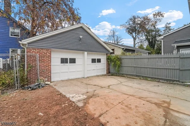 a front view of a house with a large tree