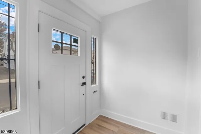 a view of a hallway with wooden floor and closet