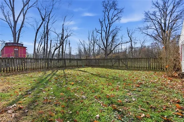 a view of backyard with wooden fence