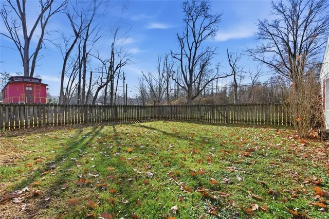 a view of backyard with wooden fence