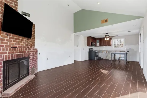 a view of kitchen living room with wooden floor and fireplace