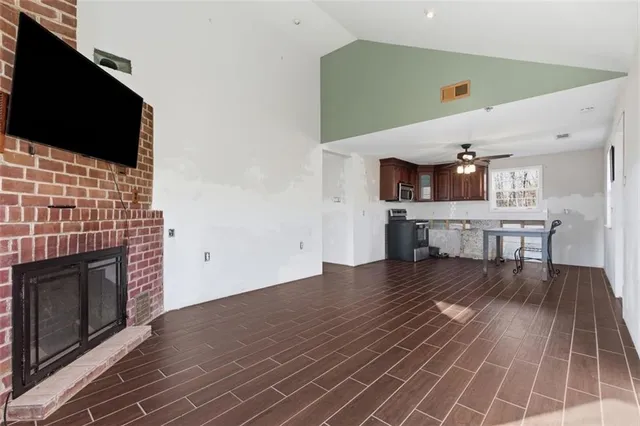 a view of kitchen living room with wooden floor and fireplace