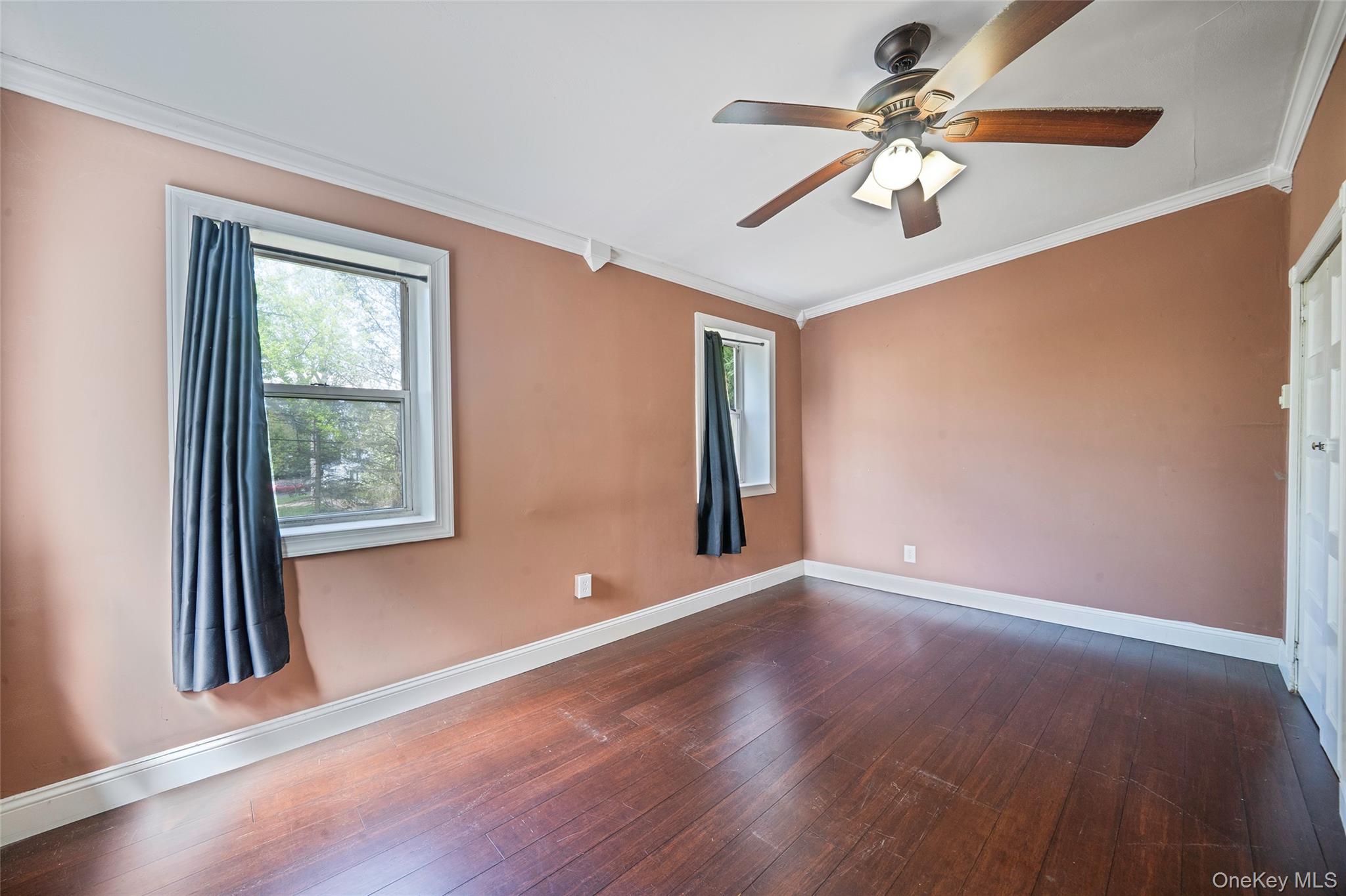 93 Maple Road Kings Park, NY 11754 - Photo 8 of 24 an empty room with wooden floor fan and windows