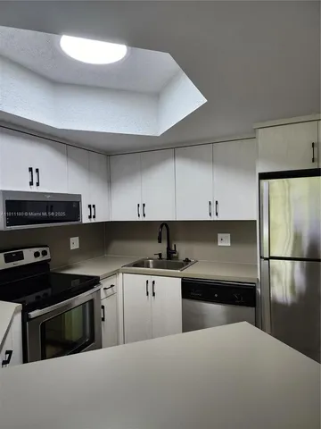 a kitchen with a sink and a stove top oven