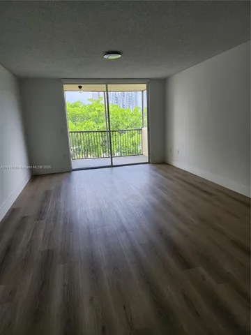 a view of a room with wooden floor and a window
