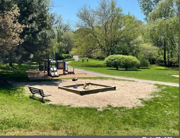 a white bench sitting in the middle of a park