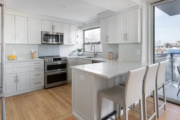a kitchen with a stove a sink and white cabinets