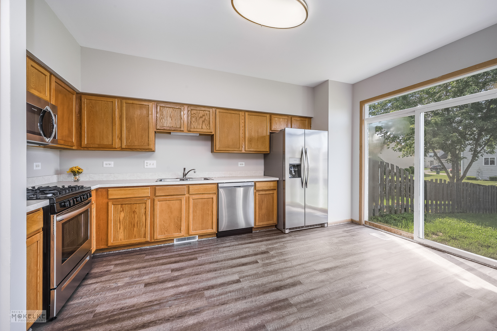 4212 Dillon Street Plano, IL 60545 - Photo 11 of 26 a kitchen with stainless steel appliances granite countertop a stove a sink dishwasher and a refrigerator with wooden floor