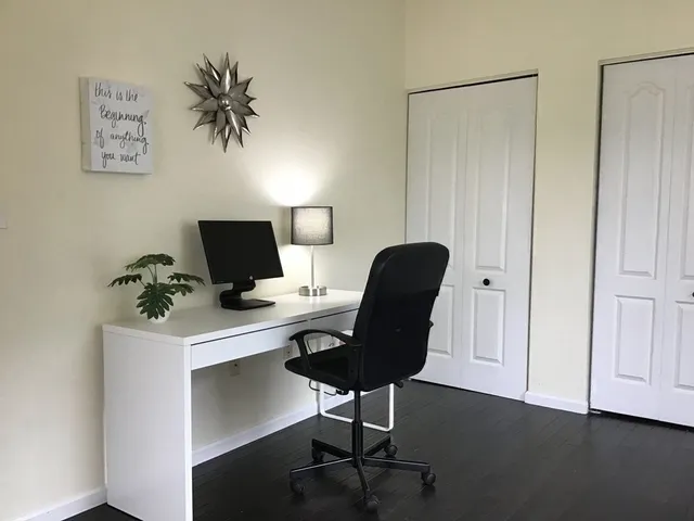 a view of a workspace with furniture and a potted plant