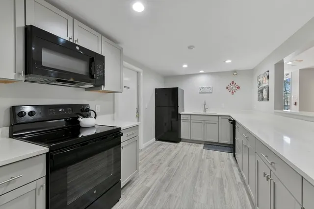 a kitchen with stainless steel appliances a stove microwave and a sink