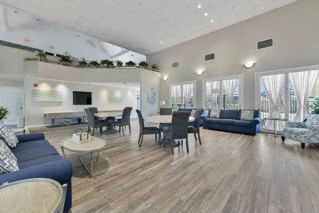 a living room with furniture dining table a lamp and a window