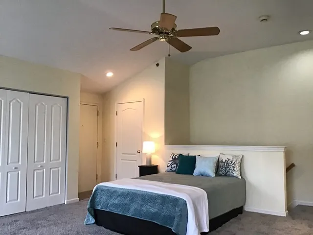 a bedroom with a bed and a ceiling fan