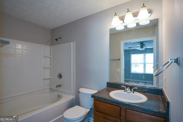 a bathroom with a sink a toilet a tub and a mirror