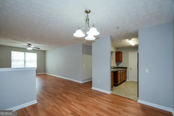 a view of a kitchen with wooden floor and a chandelier
