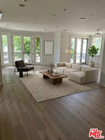 a living room with furniture and large windows