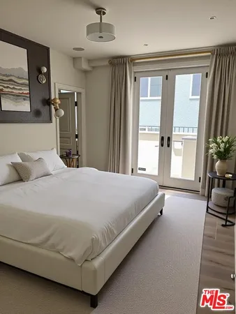 a bedroom with a large bed and a chandelier