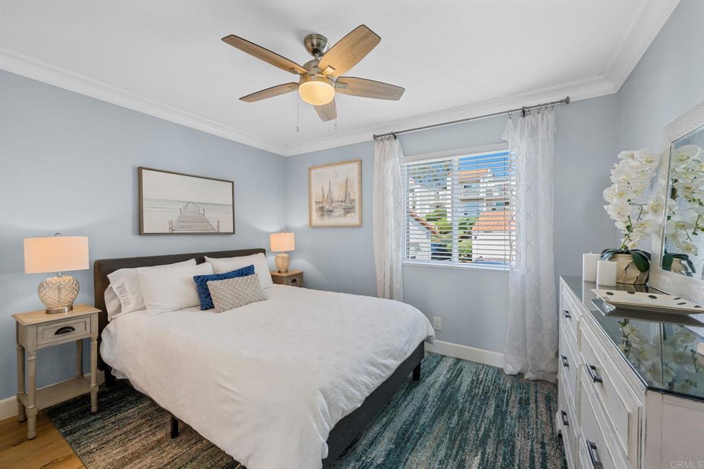 908 Caminito Madrigal, Unit D Carlsbad, CA 92011 - Photo 16 of 23 a bedroom with a large bed and a chandelier