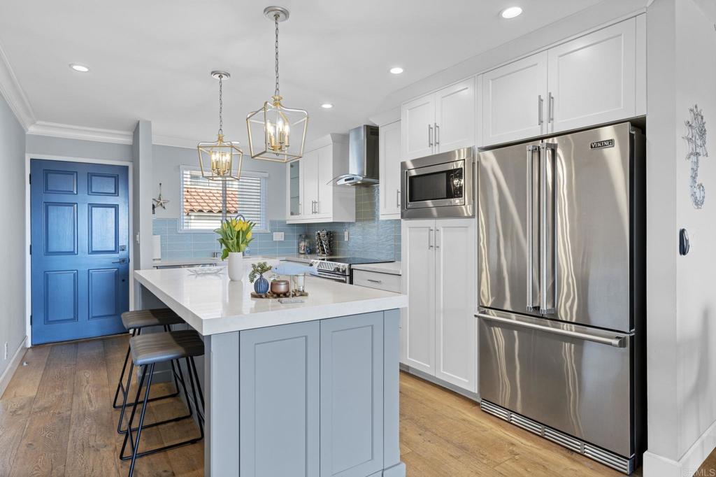 908 Caminito Madrigal, Unit D Carlsbad, CA 92011 - Photo 4 of 23 a kitchen with kitchen island a counter top space appliances and cabinets