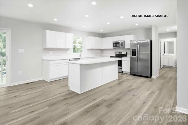 a kitchen with stainless steel appliances a refrigerator and a stove top oven