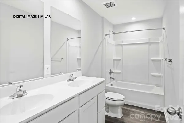 a bathroom with a granite countertop sink a toilet and shower