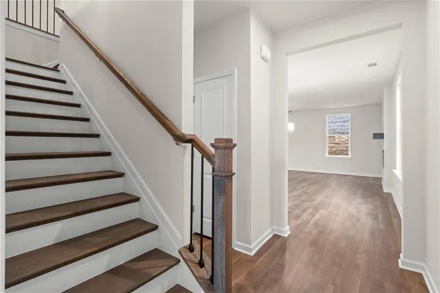 a view of a hallway with wooden floor and entryway