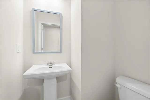 a bathroom with a sink a toilet and mirror
