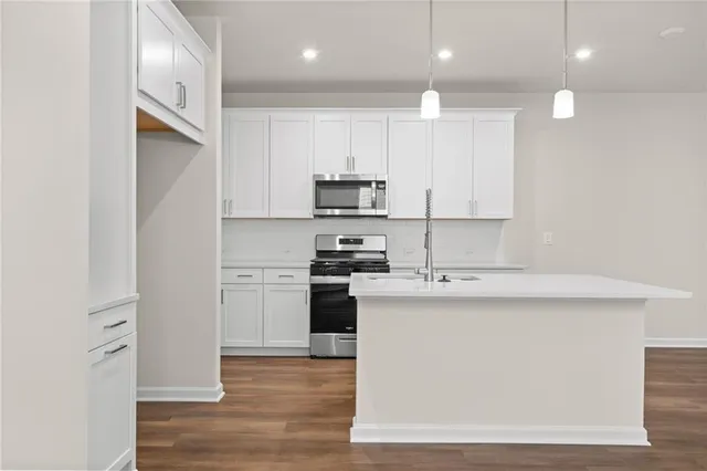 a kitchen with stainless steel appliances granite countertop a stove a sink and a refrigerator