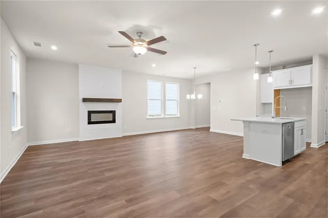 a view of an empty room with window and wooden floor