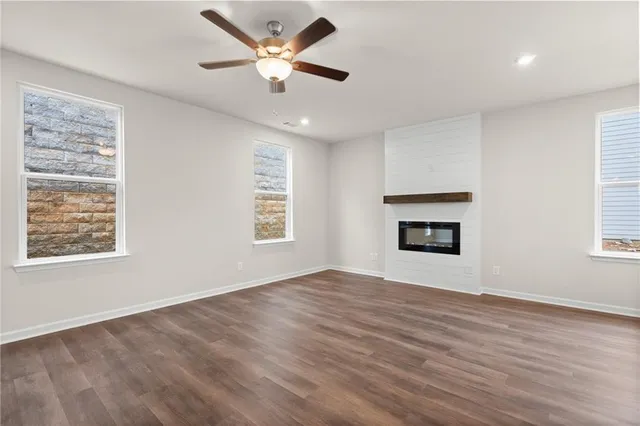 an empty room with windows and ceiling fan