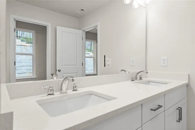 a bathroom with double vanity sinks and a mirror