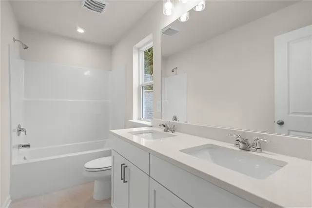 a bathroom with a granite countertop sink a toilet and bathtub