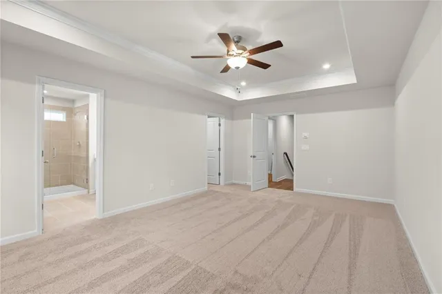 a view of an empty room with wooden floor and a ceiling fan