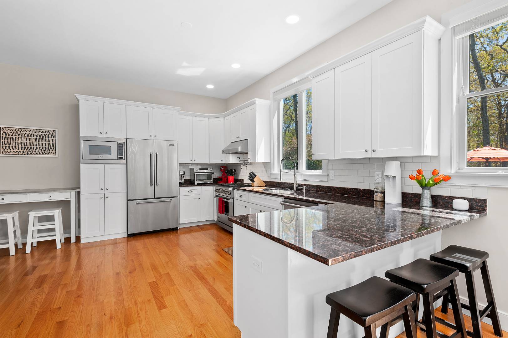 231 Norfolk Drive East Hampton, NY 11937 - Photo 3 of 17 a kitchen with stainless steel appliances granite countertop a refrigerator a stove top oven a sink dishwasher and white cabinets with wooden floor