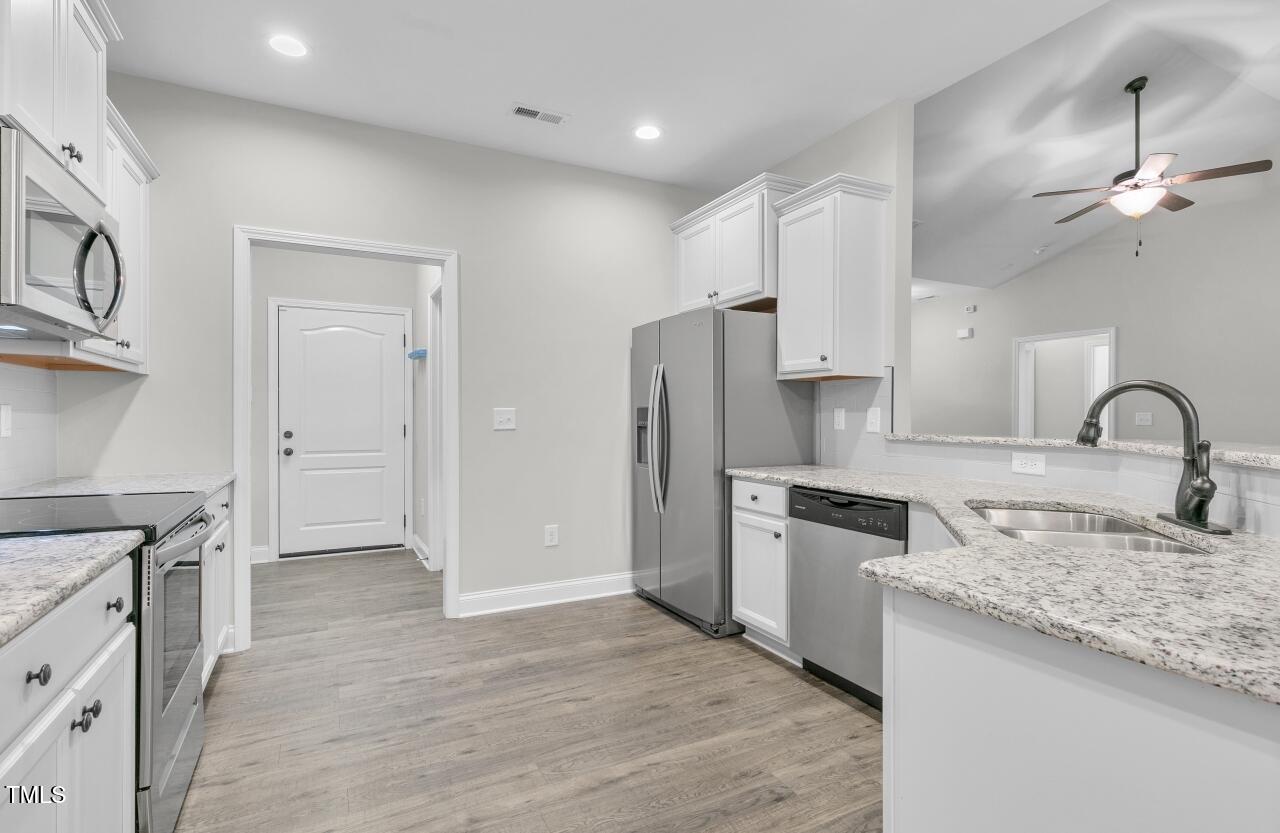 24 Highmeadow Lane Clayton, NC 27520 - Photo 11 of 37 a kitchen with granite countertop a refrigerator stove and sink