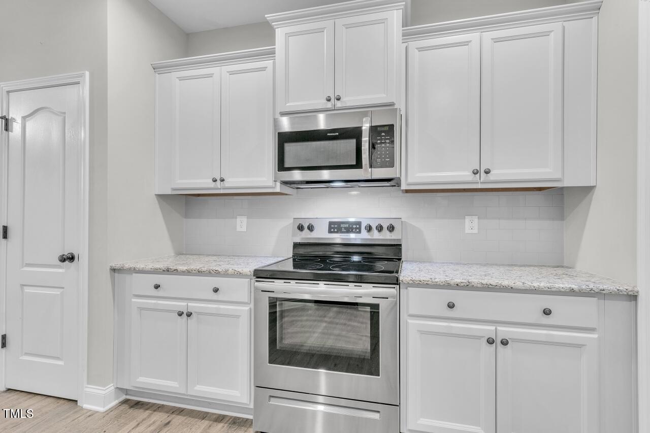 24 Highmeadow Lane Clayton, NC 27520 - Photo 12 of 37 a kitchen with white cabinets and stainless steel appliances