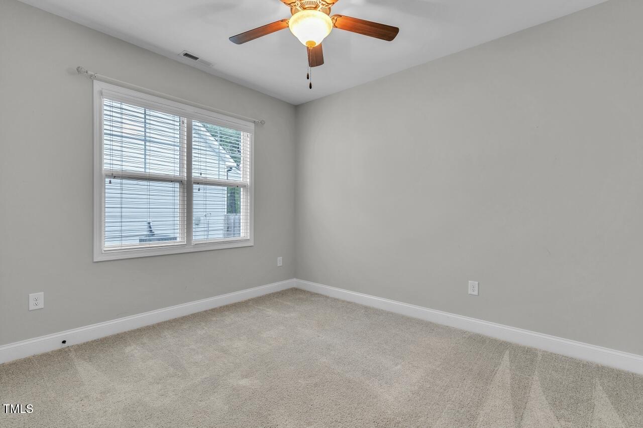 24 Highmeadow Lane Clayton, NC 27520 - Photo 30 of 37 an empty room with a window and a ceiling fan