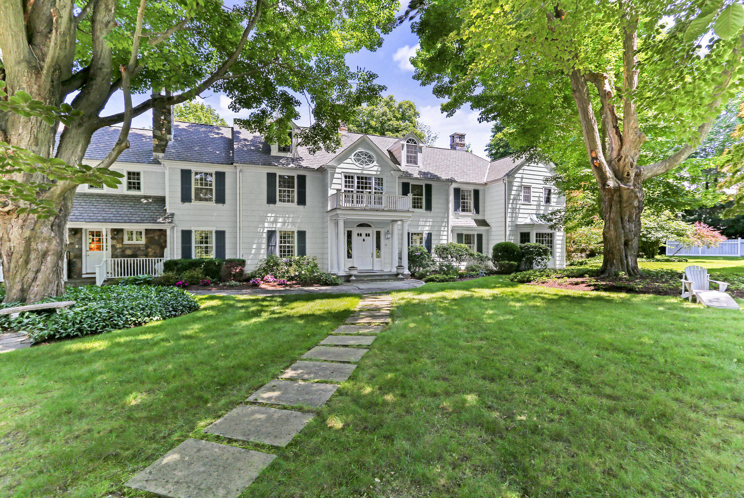 109 Rosebrook Road New Canaan, CT 06840 - Photo 1 of 47 a front view of a house with a yard table and chairs